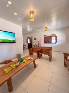 a living room with a television on a wall at Casa Mar e Rio Milagres in São Miguel dos Milagres