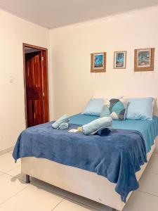 a bedroom with a bed with blue blankets and pillows at Casa Mar e Rio Milagres in São Miguel dos Milagres