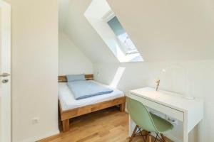 a small bedroom with a bed and a desk at Ferienhaus-Belvedere-2-c in Blekendorf