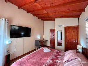 a bedroom with a bed and a flat screen tv at Hospedaje Brisas de Frutillar in Frutillar