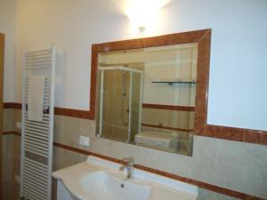 ein Bad mit einem Waschbecken und einem Spiegel in der Unterkunft Villa Carlotta in Crone