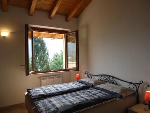 Schlafzimmer mit einem Bett und einem Fenster in der Unterkunft Villa Carlotta in Crone