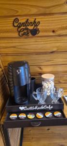 a coffeemaker sitting on top of a table with food at Chalé dos Buritis 02 in Chapada dos Guimarães