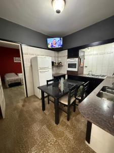 a kitchen with a black table and a refrigerator at HOSTEL del MUNDO in Villa María