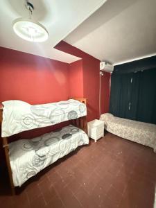 a room with two bunk beds and a red wall at HOSTEL del MUNDO in Villa María