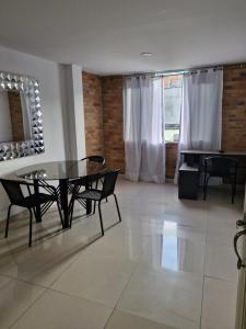 a dining room with a glass table and chairs at EDIFICIO Niza80 IBAGUE, ACCESO DIGITAL CERCA PARQUE DEPORTIVO o coliseo, diag Caí del exito in Ibagué