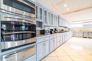 a large kitchen with white cabinets and stainless steel appliances at Sea Horizon Hotel in San Pedro
