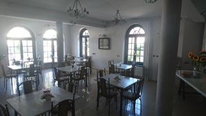 a dining room with tables and chairs and windows at Dworek Mitro in Gdynia