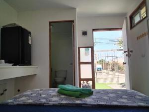 a bedroom with a bed with a green towel on it at Casa Jupiter in Villa Alemana