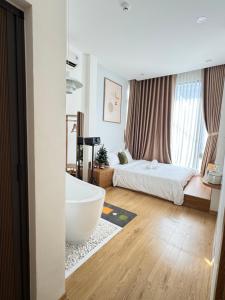 a bathroom with a tub and a bed in a room at Tue Anh Homestay in Cồn Giả Viên