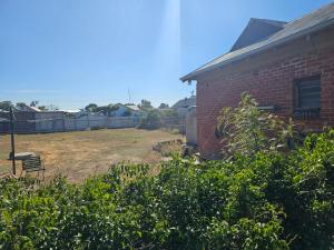 a brick building with a bench in a yard at Commercial Hotel in Birchip