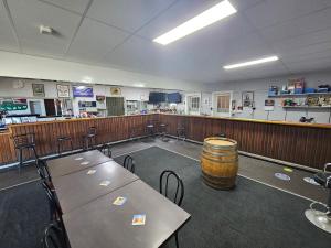 a large room with tables and chairs and a barrel at Commercial Hotel in Birchip