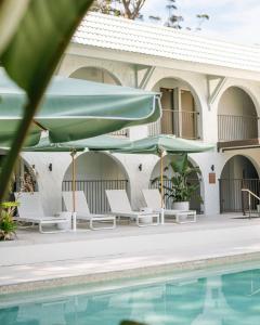a villa with a swimming pool and umbrellas at The Tamborine - Boutique Hotel in Mount Tamborine