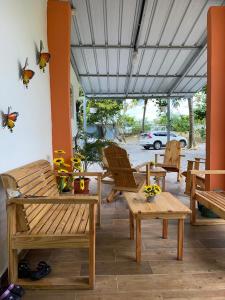 a patio with wooden benches and butterflies on the wall at Rancho Doña Rita in Higuey