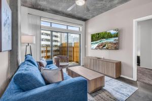 a living room with a blue couch and a tv at The Nomad Roosevelt in Phoenix