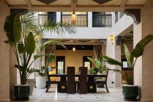 a dining room with a table and potted plants at Private Riad Alemania in Marrakesh - Pool - Rooftop in Marrakesh