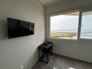 a room with a desk and a window and a television at Cabo Marino Apartment, Pool, Beach and Marina in Conchal