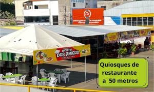 a sign for a restaurant with tables and chairs at Flat no Centro da Cidade in Parauapebas
