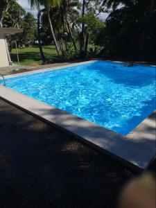 a large blue swimming pool next to a house at Yatu Lau Transit Hotel in Nadi