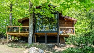 a tree house in the woods with a deck at Stunning Lakeview Muskoka Pier 100 Resort in Port Carling