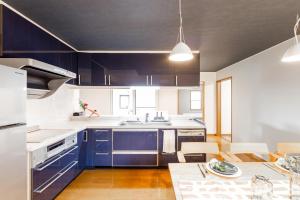 a kitchen with dark blue cabinets and a table at THE WORLDWIDE HOUSE in Sapporo