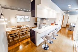 a kitchen with a counter and stools in a room at THE WORLDWIDE HOUSE in Sapporo