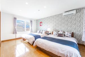 a bedroom with two beds and a window at THE WORLDWIDE HOUSE in Sapporo