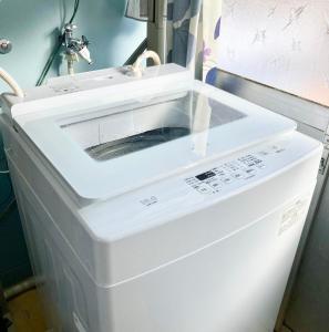 a white dishwasher in a kitchen with a sink at Zaō Hütte 一棟貸し in Zao
