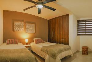 a bedroom with two beds and a ceiling fan at Casa Prisma amplitud y privacidad in Chihuahua