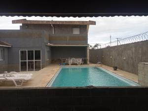 a swimming pool in the backyard of a house at Hostel da Duda II in Itanhaém
