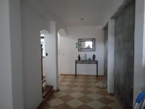 a hallway with a table and a mirror on a wall at Hostel da Duda II in Itanhaém