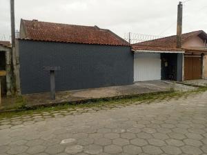 a blue building with a white door next to a street at Hostel da Duda II in Itanhaém