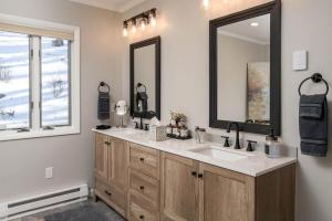 a bathroom with two sinks and a large mirror at The Buc's Den in Beech Mountain +49 photos