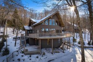 a log home with snow on the ground at The Buc's Den in Beech Mountain