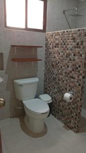 a bathroom with a toilet and a brick wall at Ecohotel Shalom in Valladolid +52 photos
