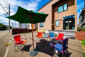 a table with chairs and an umbrella in front of a building at THE WORLDWIDE HOUSE in Sapporo +205 photos