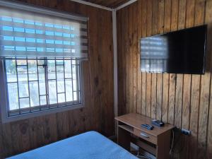 a bedroom with a bed and a television on the wall at Hostal Rancel in Angol