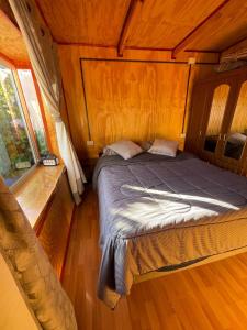 a bed in a room with a wooden ceiling at Cabañas Maite Panguipulli Calafquen 2 in Huellahue