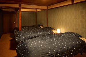 a bedroom with two twin beds in a room at Hinosawa Riverside Lodge 水遊び宿日野沢 in Minano