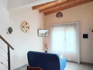 a living room with a blue chair and a clock at Village Pehuen in Balneario Pehuén-Có