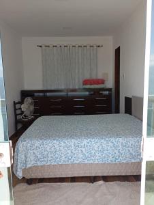 a bedroom with a bed and a dresser at J U N Q U E I R A i in Mangaratiba