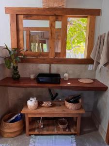 a shelf in a room with a mirror and baskets at Casa Kaûma in Corumbau +26 photos