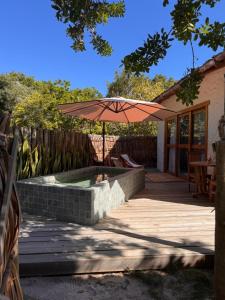 a patio with an umbrella next to a house at Casa Kaûma in Corumbau