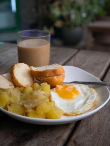 a plate with an egg and bread and a glass of milk at TT Premium Hostel Vientiane in Vientiane