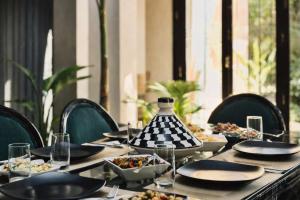 a table with plates and bowls of food on it at Private Riad Alemania in Marrakesh - Pool - Rooftop in Marrakesh