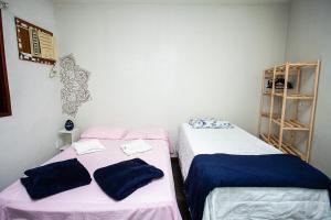 two beds sitting next to each other in a room at Espaço Sideral - Quartos com ar-condicionado, 5min Estádio Maracanã, 8min UERJ, shopping, 12min metrô, wi-fi 300mbp, ampla área comum com cozinha - prático e confortável in Rio de Janeiro