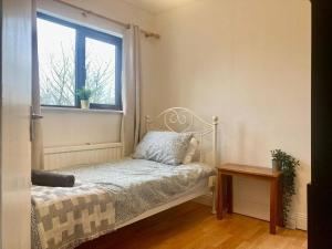 a small bed in a room with a window at Leixlip 4-Bed Home Sleeps 6 Ideal for Groups in Kildare +5 photos