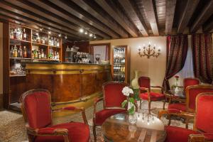 a bar with red chairs and a table in a room at Residenza d'Epoca San Cassiano in Venice