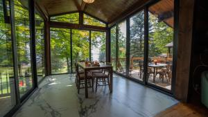 a dining room with large windows and a table with chairs at Stunning Lakeview Muskoka Pier 100 Resort in Port Carling