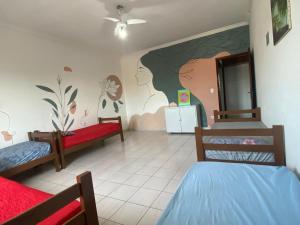 a room with two beds and a painting on the wall at Hostel Casarão SV in São Vicente